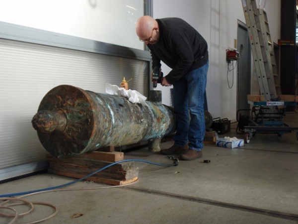 Lucas van Dijk takes a sample from a bronze cannon.
